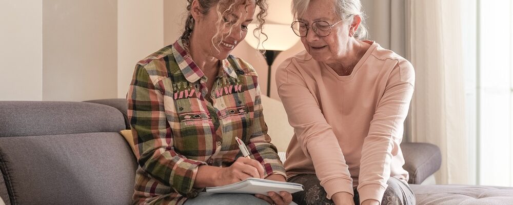Smiling,Senior,Woman,And,Caregiver,Sharing,A,Moment,Sitting,Together Smiling,Senior,Woman,And,Caregiver,Sharing,A,Moment,Sitting,Together