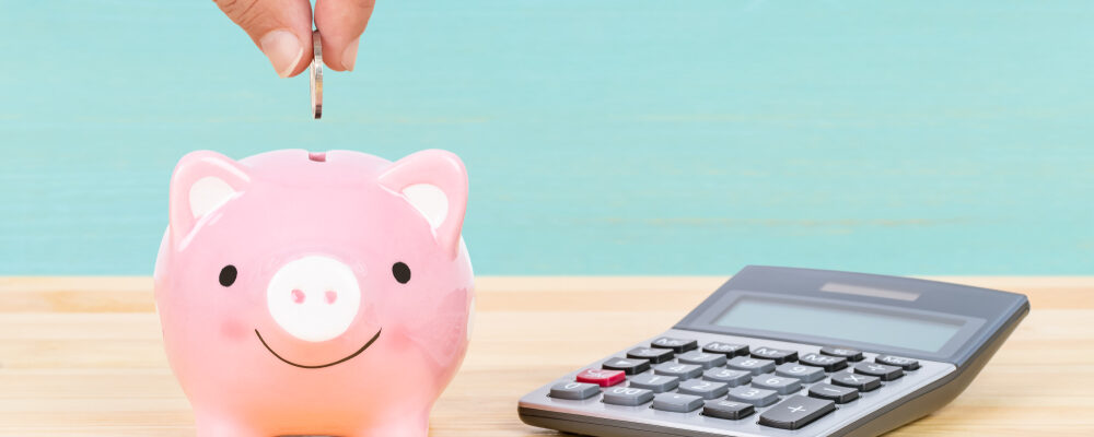 Piggy,Bank,With,Hand,Putting,Insert,Coin,And,Calculator,,On Piggy,Bank,With,Hand,Putting,Insert,Coin,And,Calculator,,On